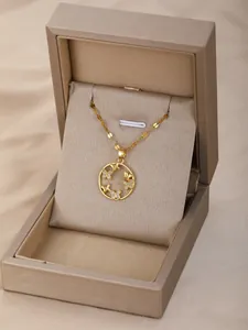 Detalle de un collar circular con mariposas doradas en una caja de regalo elegante