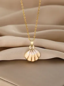 Detailed close-up of golden scallop shell pendant necklace on elegant champagne satin