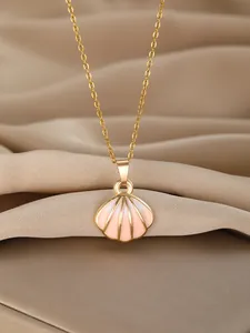 Detail of gold shell pendant with pink enamel finish on elegant beige satin fabric