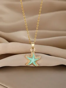 Detail of mint green starfish pendant necklace with gold beads on champagne silk