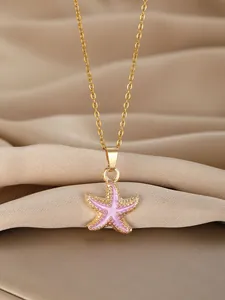 Close-up of golden starfish pendant with pink enamel and dot engraving on champagne silk