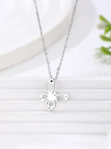 Close-up of minimalist stainless steel butterfly pendant with hollow wing detail