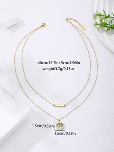 Detailed close-up of double-layer gold necklace with tree of life pendant and s-steel tag