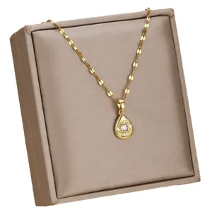 Collar de Ojo Turco dorado con cadena de escamas en una caja de joyería premium