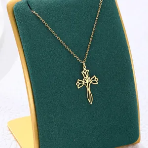 Elegant gold titanium steel necklace with hollow floral cross pendant on velvet stand