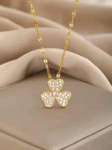 Macro shot of gold floral pendant with pavé cubic zirconia and intricate chain detail