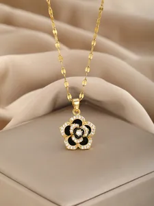 Detailed close-up of a floral pendant necklace with black enamel and white zircons
