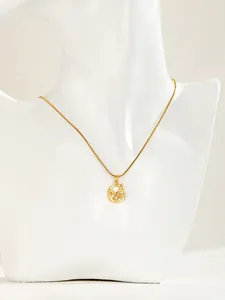 Detail of gold butterfly pendant with zircon on sleek snake chain for women