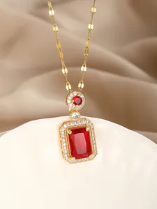 Macro detail of luxury gold necklace with rectangle red gemstone and sparkling zircons