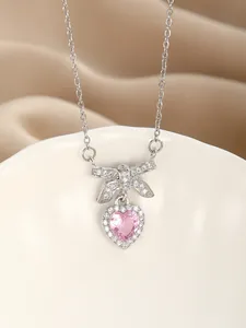 Macro shot of S925 silver necklace with pink heart zircon and sparkling bow detail