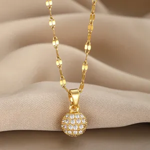 Macro shot of a gold-plated spherical pavé pendant with sparkling zircons on a ribbon chain