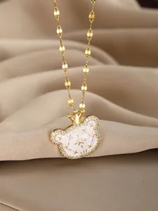 Close-up of golden bear pendant with white enamel star and shimmering cubic zirconia stones
