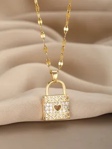 Detailed macro of gold padlock pendant with heart cutout and pavé cubic zirconia