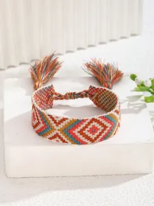 Detalle de una pulsera tejida bohemia con coloridos patrones geométricos de diamantes