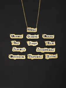 Macro detail of twelve zodiac necklaces with gothic lettering and gold layering