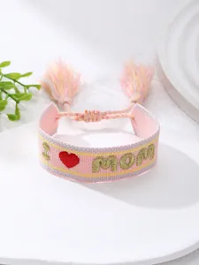 Vista detallada de la pulsera bordada rosa con texto dorado I Love Mom y borlas suaves