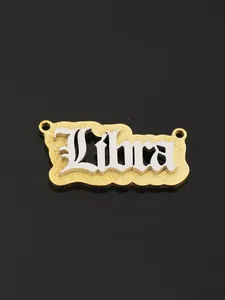 Macro shot of two-tone Libra pendant with silver Gothic font on gold frosted metal base