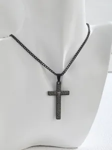Close-up of black stainless steel cross pendant with engraved Lord's Prayer on a necklace