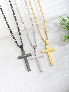 Detailed macro view of three Lord's Prayer cross pendants in black, silver, and gold steel