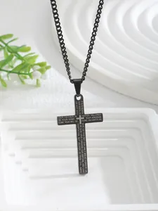 Close-up of black stainless steel cross pendant with engraved Lord's Prayer text
