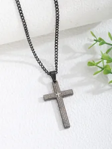 Macro view of black stainless steel cross pendant featuring engraved Lord's Prayer text