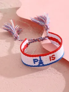 Primer plano de la pulsera tejida PARIS con motivo de la Torre Eiffel y flecos de colores