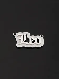 Macro detail of silver Leo name pendant with gothic font and frosted metallic texture