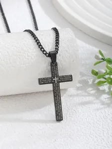 Macro shot of black stainless steel cross pendant featuring The Lord's Prayer engraving