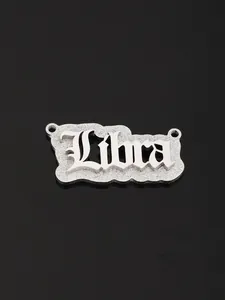 Macro view of polished silver Libra zodiac pendant with gothic lettering and matte base