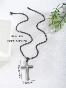 Close-up of black matte stainless steel cross pendant with engraved Lord's Prayer