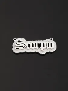 Macro shot of silver stainless steel Scorpio zodiac pendant in gothic font detail