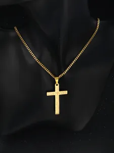 Close-up of golden cross pendant with engraved Lord's Prayer on a cuban chain