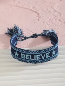 Detalle de la pulsera de la amistad BELIEVE bordada con borlas azules y estrellas