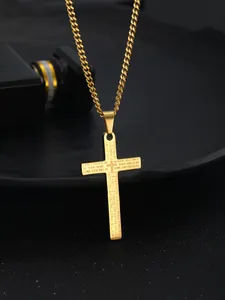 Macro shot of gold cross pendant with engraved Lord's Prayer on a Cuban chain