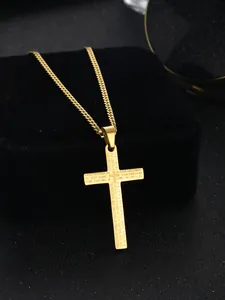 Close-up of golden stainless steel cross pendant engraved with The Lord's Prayer text