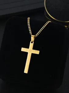 Macro shot of gold stainless steel cross pendant with Lord's Prayer engraving detail