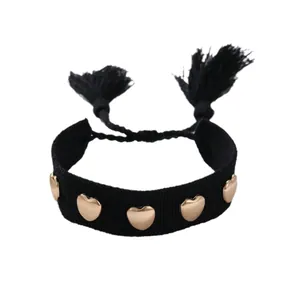Pulsera tejida negra con dijes de corazones dorados y borlas para mujeres