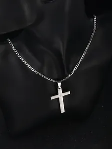 Macro shot of silver stainless steel cross pendant with engraved Lord Prayer on Cuban chain