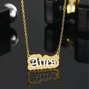 Aries zodiac necklace in gold and silver stainless steel on reflective surface