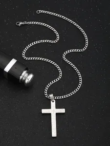 Detailed macro shot of the Lord's Prayer engraving on a stainless steel cross pendant