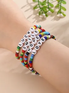 Nahaufnahme bunter Boho-Perlenarmbänder mit den Schriftzügen LUCKY SMILE HOPE LOVE