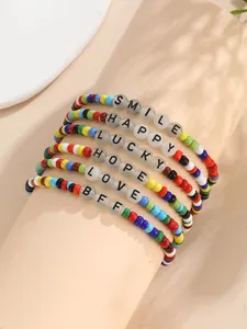Primer plano de seis pulseras de cuentas de colores con letras inspiradoras como SMILE y LOVE