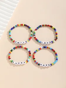 Detailansicht vierteiliges Set bunte Boho-Perlenarmbänder mit SMILE und LOVE Schriftzug