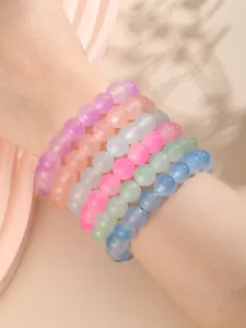 Detalle de pulseras de cuentas de vidrio esmerilado en colores pastel macarrón