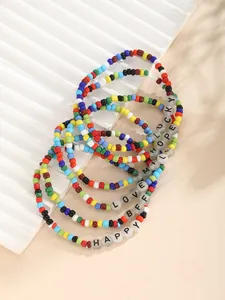 Detalle de set de pulseras de cuentas de colores con dijes de letras LUCKY y LOVE