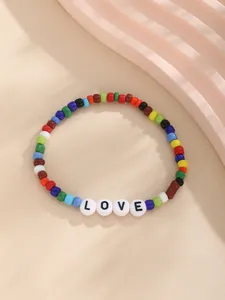 Makro-Detail des bunten Boho-Perlenarmband mit schwarzen LOVE Buchstaben auf Perlen