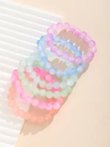 Detalle macro de pulseras de cuentas de vidrio esmerilado en tonos pastel de macaron