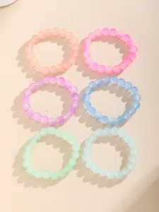 Detalle de set de 6 pulseras de cuentas coloridas en tonos pastel translúcidos