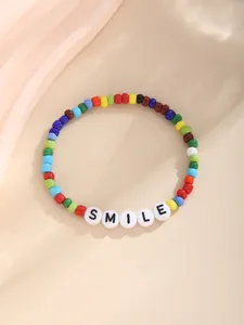 Detail eines böhmischen Armbands mit bunten Perlen und weißen SMILE-Buchstabenperlen