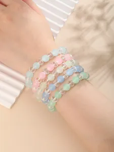 Primer plano de pulseras de cuentas en tonos macaron con texturas mate y de cristal